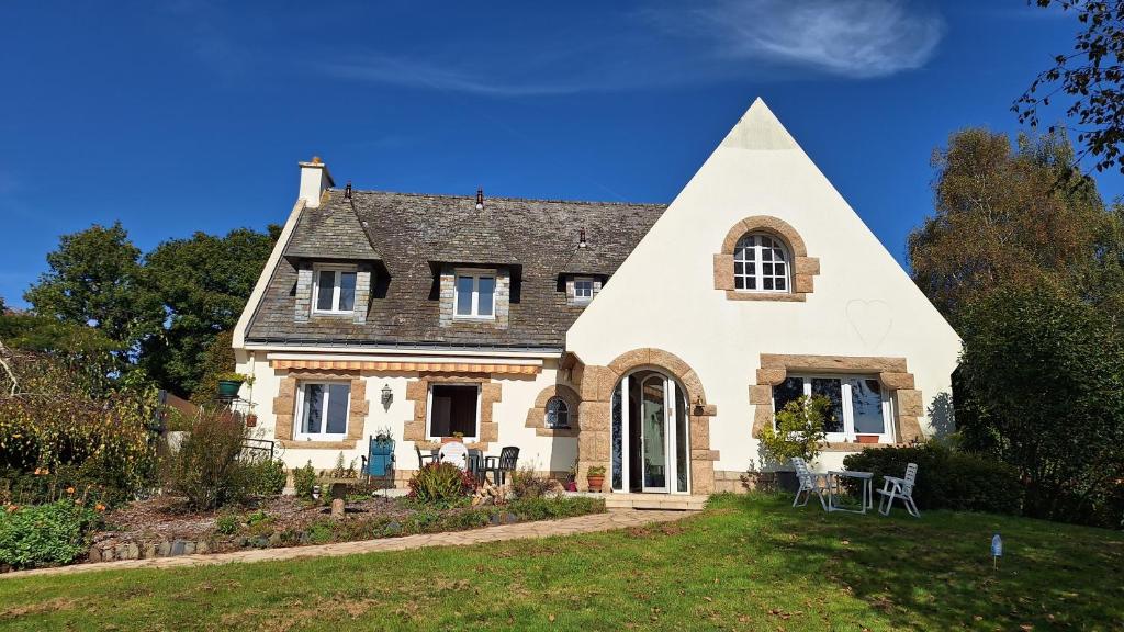 a large white house with a pointed roof at Bolumet in Neulliac