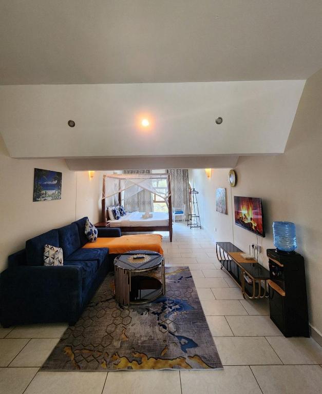 a living room with a blue couch and a table at Beachfront Studio in Diani Beach