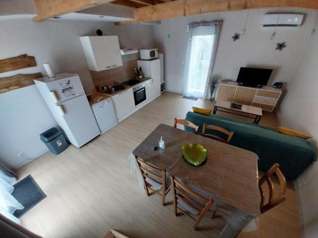 a living room with a table and a kitchen at Gites Les Granges De Flolie in Beauteville