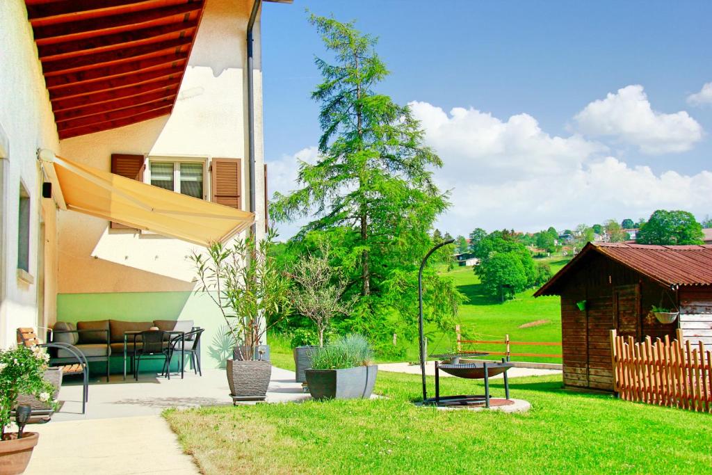 a house with a patio with a table and chairs at La Boutique in Saignelégier
