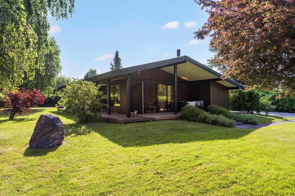 a small house in a yard with a rock at FY348-Svendborg-Storkenaebsvej-1 in Svendborg