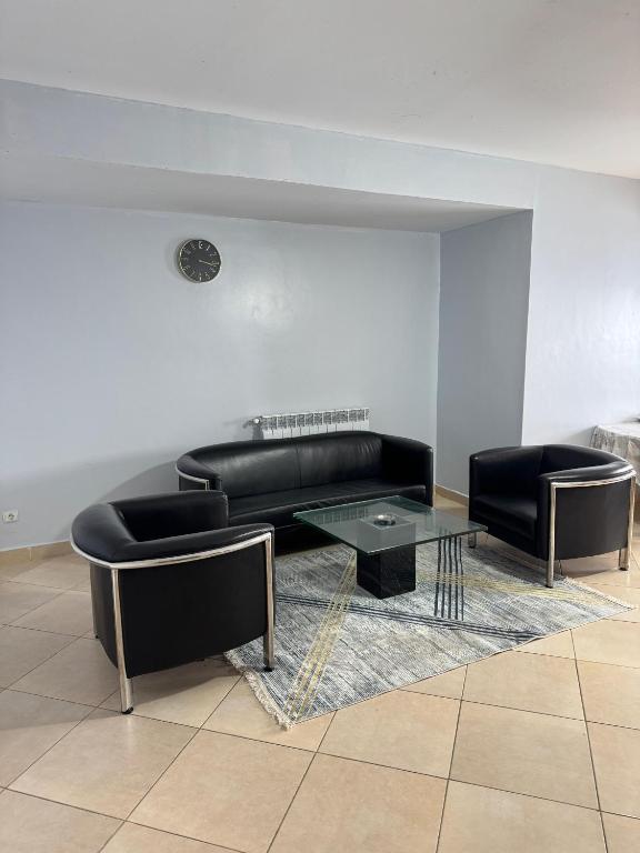 a living room with a black couch and a table at Harmony immo in Bir el Djir