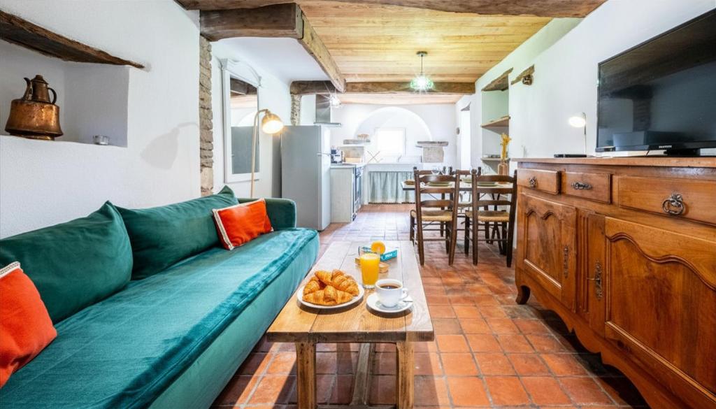 a living room with a green couch and a table at L'Abeille Maison - Proximité Dijon et Circuit Dijon Prenois in Vantoux