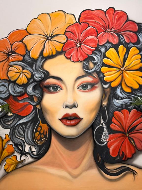 a painting of a woman with flowers on her head at HHHH Hostel in Banyuwangi