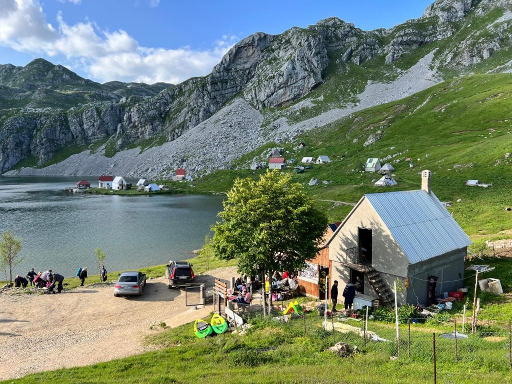 a group of people standing around a small building next to a lake at Rural Household MINIĆ - Kapetanovo jezero in Kolašin