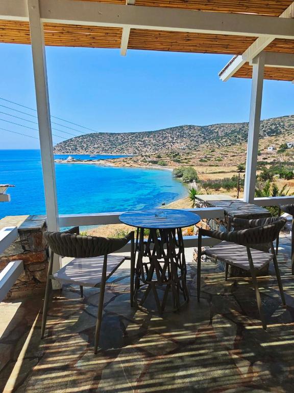a table and chairs on a porch with a view of the ocean at Alezina studios in Amorgos