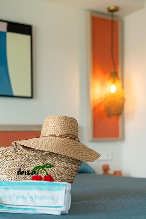 a straw hat sitting on top of a bed at The White Apartments in San Antonio