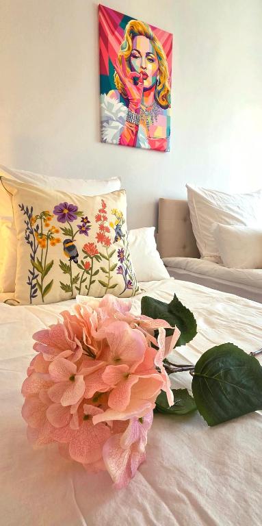 a pink flower sitting on top of a bed at Lake&Mountain Apartments in Andechs