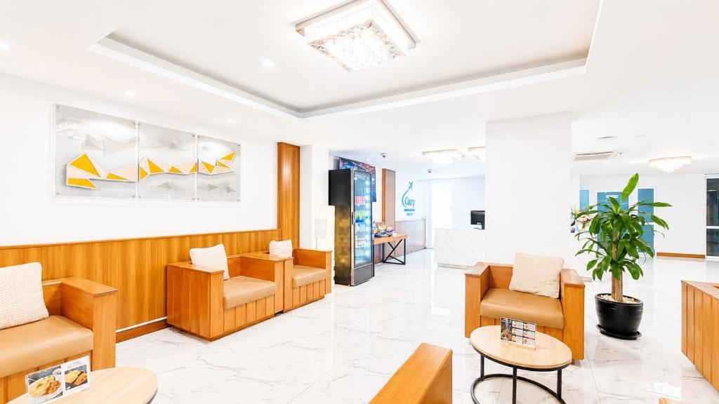 A bright seating lounge with armchairs, sofas and a marble floor.