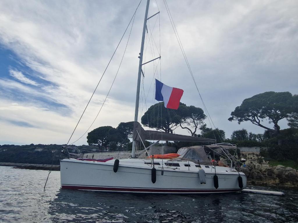 a white boat with a flag on the water at Echappée belle in Cros-de-Cagnes