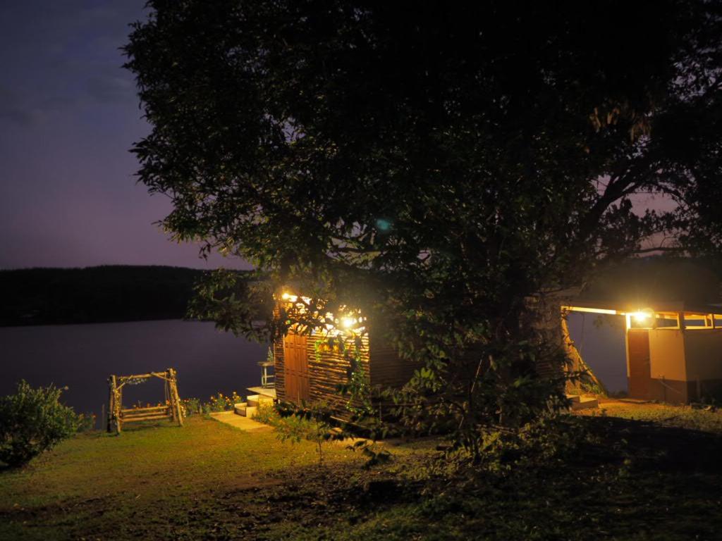 a night time picture of a house by the water at บ้านสวนริมอ่าง in Phayao