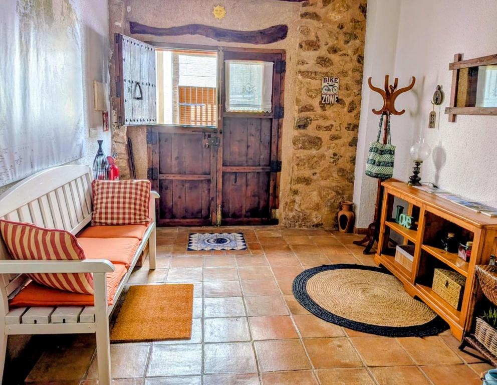 ein Wohnzimmer mit einer Couch und einer Holztür in der Unterkunft Can Lluna in Tárbena
