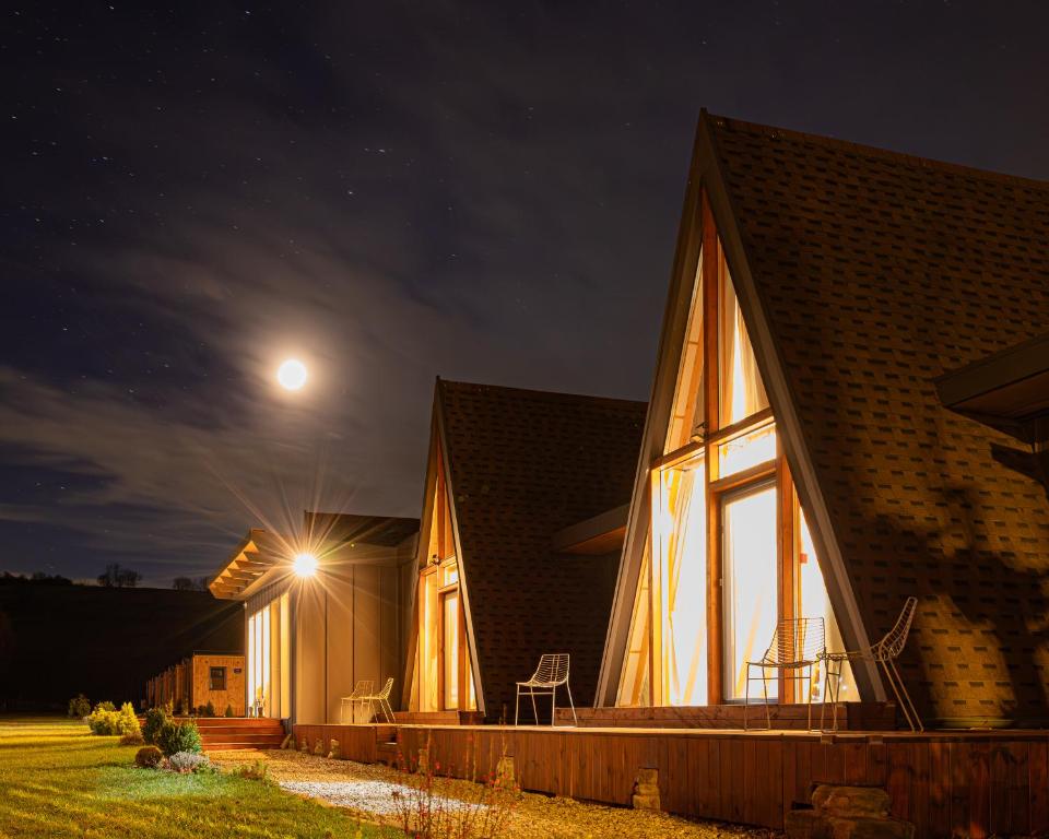 a house at night with the moon behind it at Lala Camp in Vama Buzăului