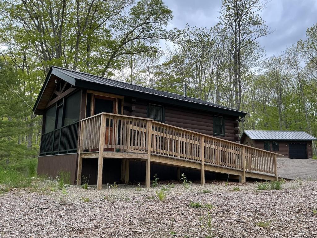 a log cabin with a porch and a deck at Rivers Edge Cabins - Cozy Lookout in Cushing