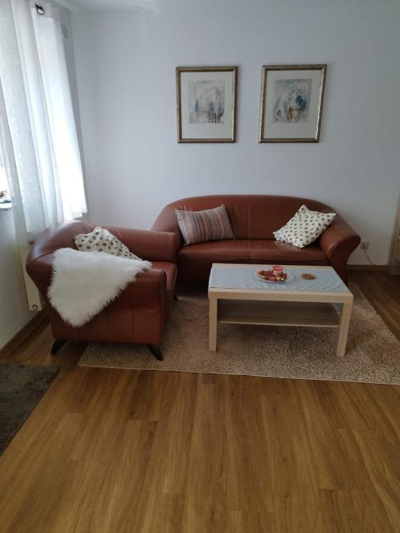 a living room with a brown couch and a coffee table at Gästezimmer mit eigenem Eingang in Schwäbisch Hall