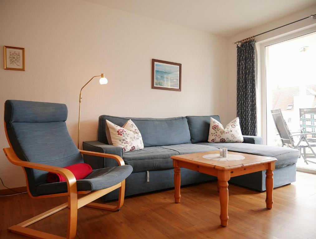 a living room with a blue couch and a table at Tschach in Kirchdorf