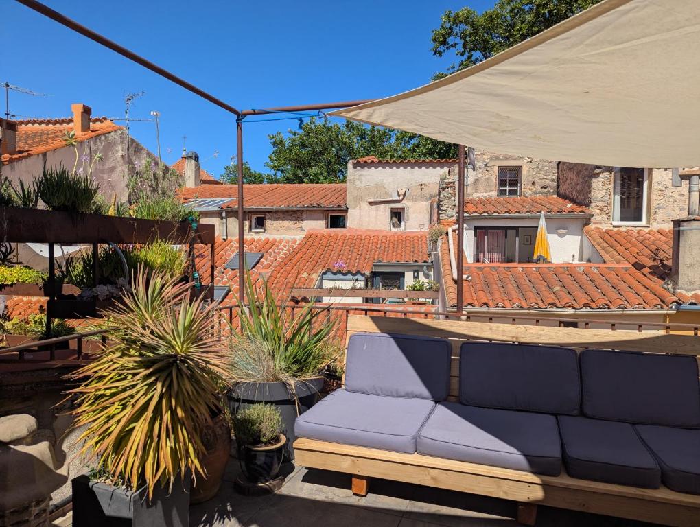 a blue couch sitting on a patio with plants at The Artist's House in Céret