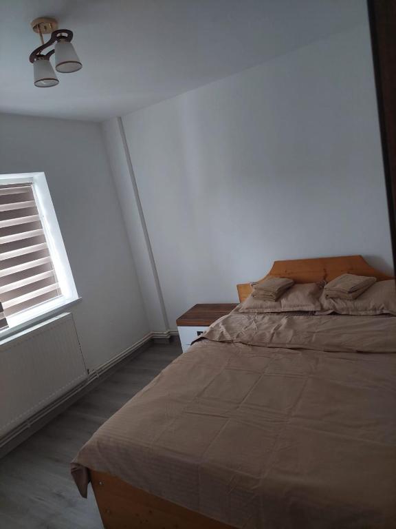 ein Schlafzimmer mit einem Bett und einem Fenster in der Unterkunft Home2 in Fălticeni