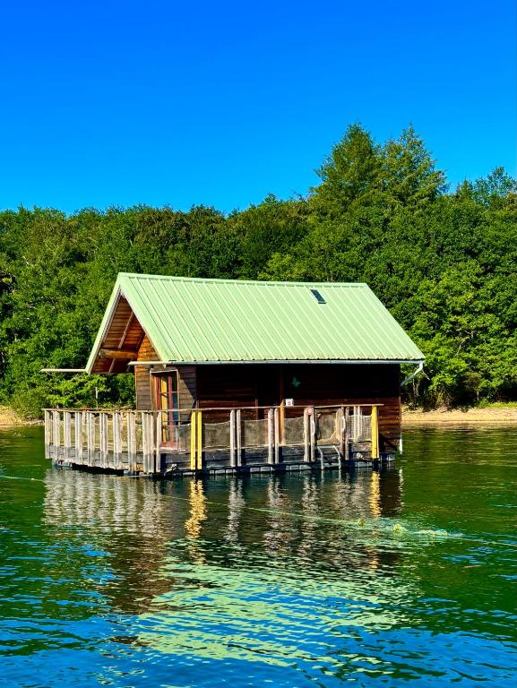 a cabin on a dock on a body of water at Chalets flottants lac de Saint Étienne Cantalès in Saint-Gérons