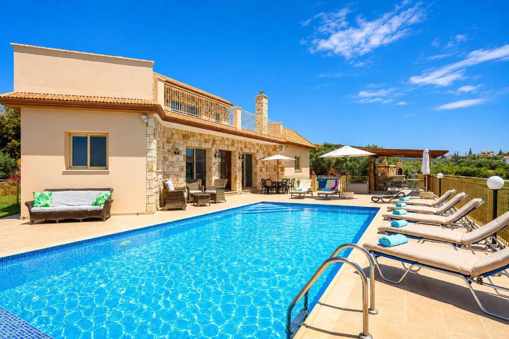 a villa with a swimming pool and a house at Villa Christel in Lachi