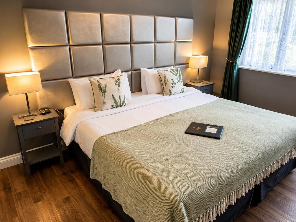 a bedroom with a large bed with a large headboard at The Farmers Boy Inn Guest House in Longhope