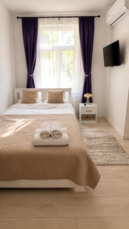 a bedroom with a bed with two towels on it at Garsoniera lângă Palatul Parlamentului in Bucharest