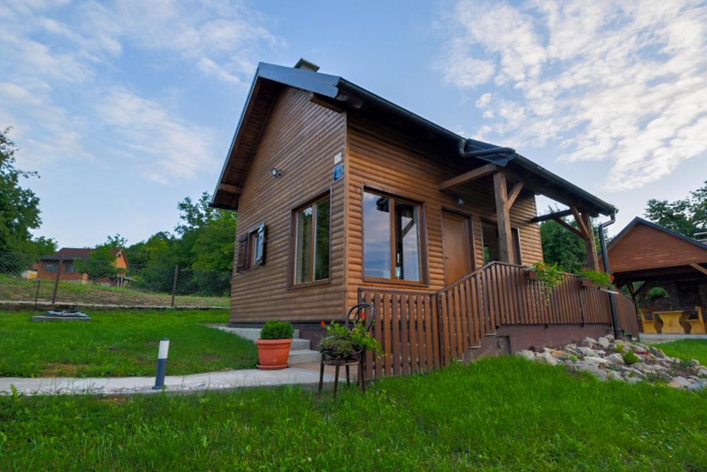 a small wooden house in a field of grass at Golubek Holiday House in Banščica