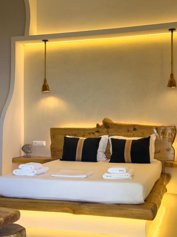 a bedroom with a bed with two plates on it at Villa Alisachni Andros in Agia Eleousa