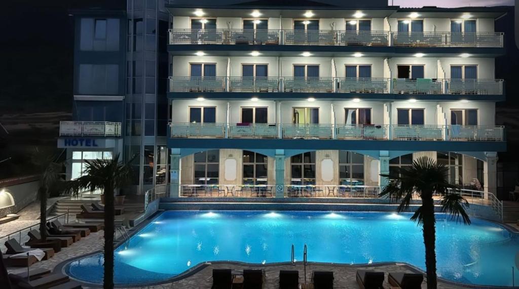 a hotel with a swimming pool at night at Kompleksi LYHNIDAS in Pogradec