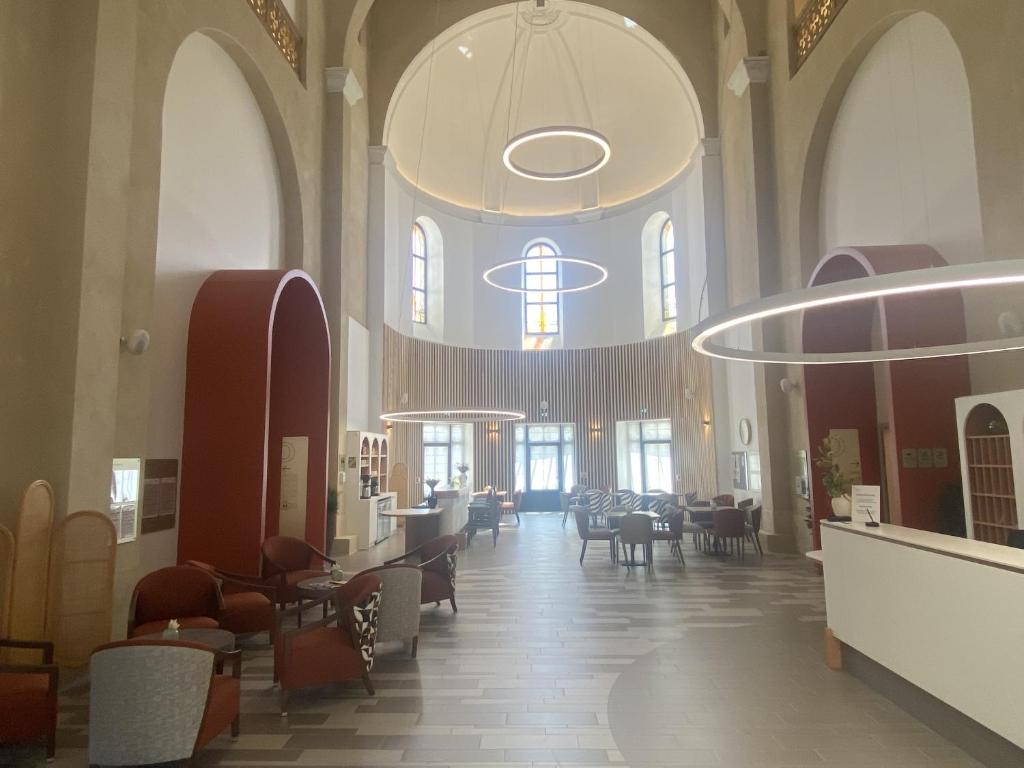 a large room with tables and chairs in a building at DOMITYS - Villa Molinis in Moulins