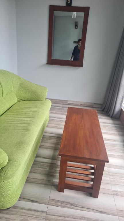 a living room with a green couch and a table at Ramboda Rest in Nuwara Eliya