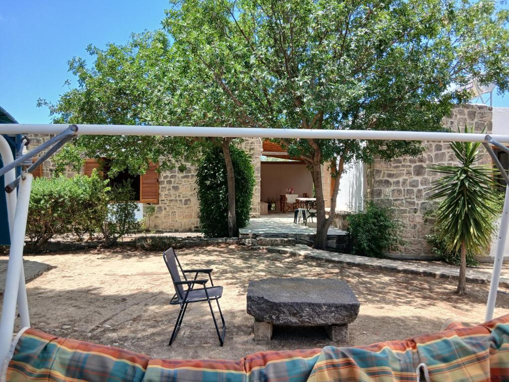 a chair and a bench in a yard at Egina Home in Egina