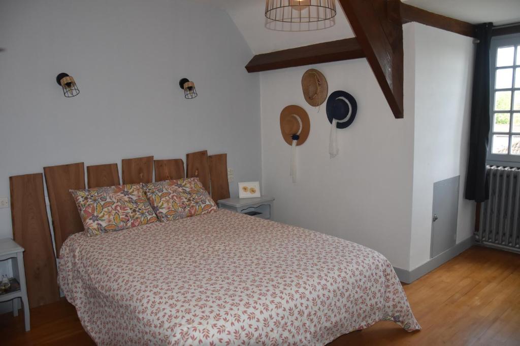 a bedroom with a bed with a comforter at Pause Périgord in Saint-Cyprien
