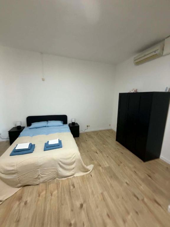 a bedroom with a bed and a wooden floor at 1 Grande Chambre Frigo privé in Charleroi