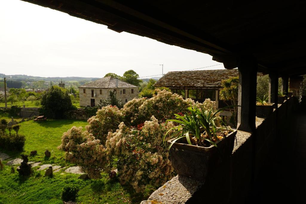 a view of a garden with plants and a house at Casa de San Pedro de Cerceda in Villasante