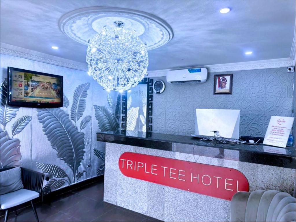 ein Hotelrezeptionstresen mit Kronleuchter in einem Zimmer in der Unterkunft Triple Tee Hotel in Lagos