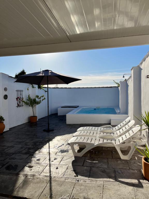 a patio with a bench and an umbrella at La Casilla in Montilla