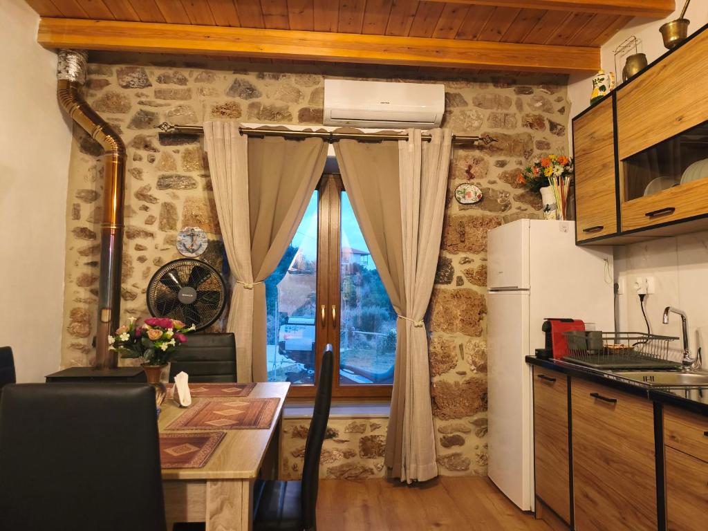 a kitchen with a stone wall and a window at Tsitsinos Village Cottage in Zekros