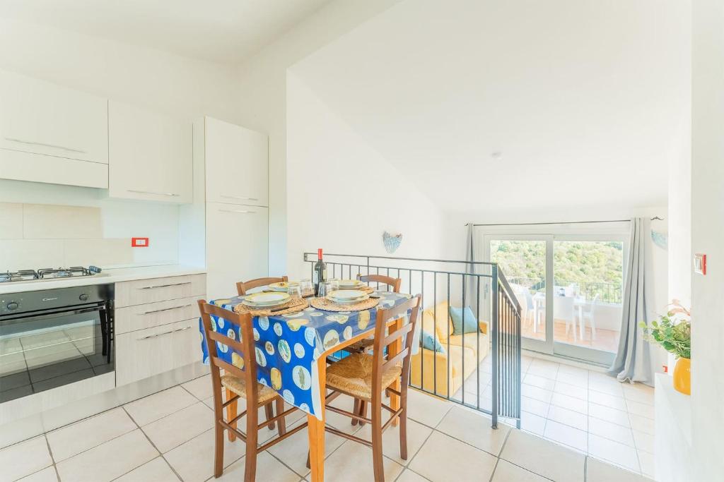 a kitchen with a table and chairs and a balcony at Chic Residence Ea Bianca 1 Bed Apartment sleeps 4 in Cala Bitta