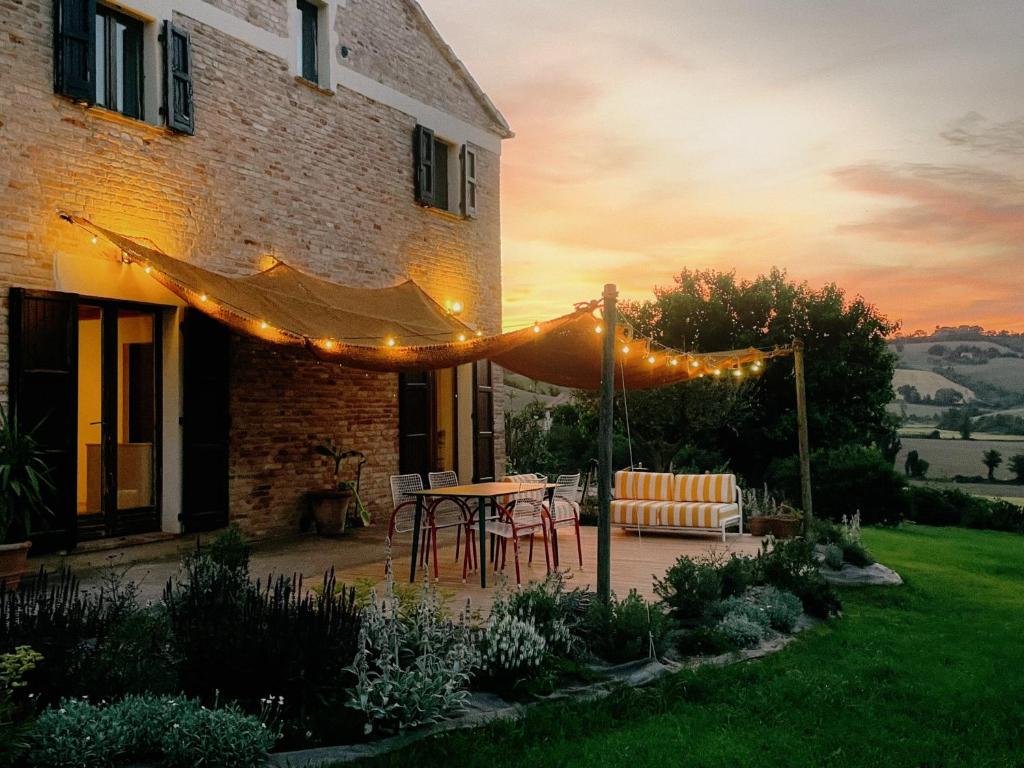 a patio with a table and chairs and lights at Casale Milleluci - Country House in Senigallia