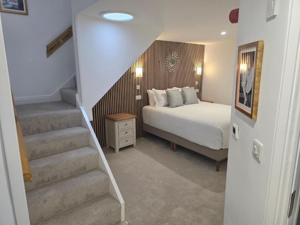 a bedroom with a bed and a stair case at Dunderry Lodge Luxury Suites in Navan