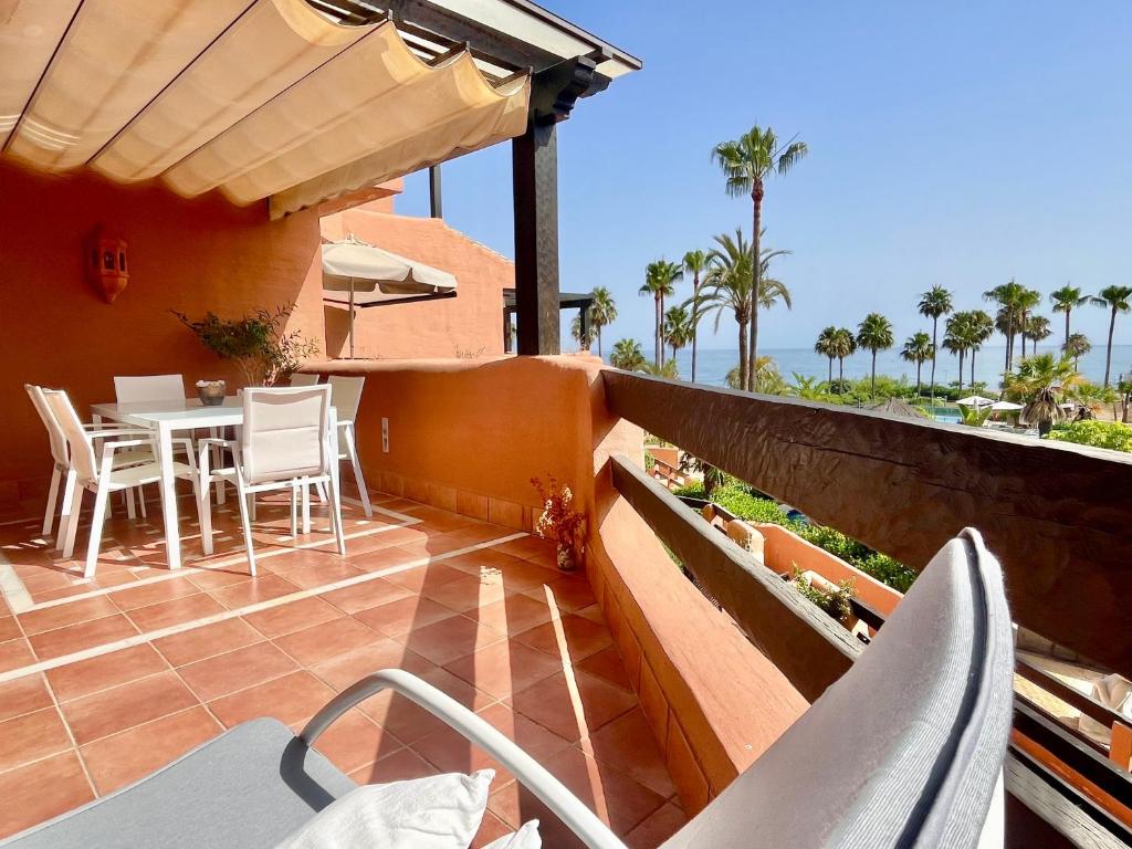 a patio with a table and chairs on a balcony at Beach front apartment Mar Azul in Estepona