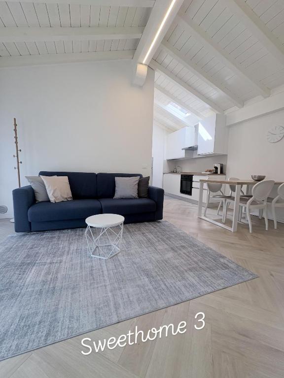a living room with a blue couch and a table at Sweet & Home in Azzano San Paolo