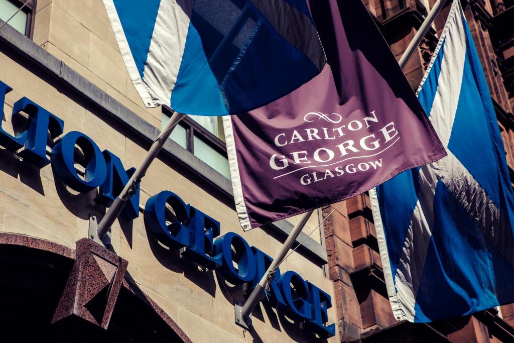 a sign on the side of a building with a flag at Carlton George Hotel in Glasgow