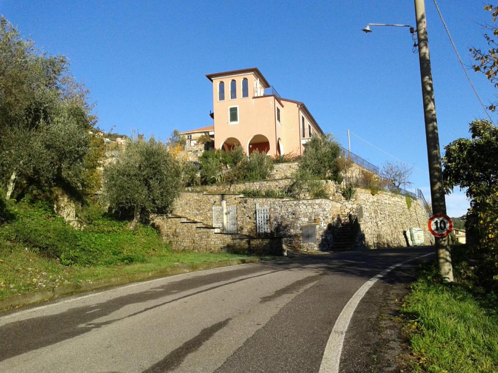 uma casa no lado de uma colina com uma estrada em La Torretta Rosa em La Spezia