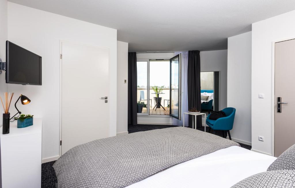 a bedroom with a bed and a view of the ocean at Ténéo Apparthotel Talence Espeleta - Bordeaux Sud in Talence