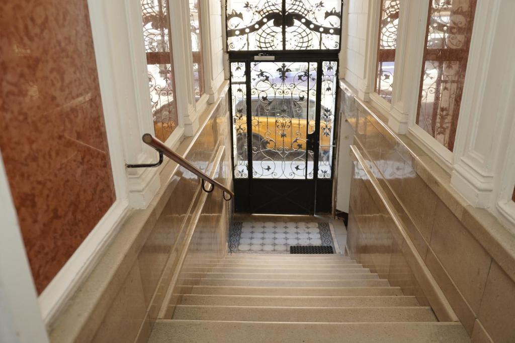 a hallway with a black door and stairs at Cozy&Quiet Apartment near Schönbrunnpalace in Vienna