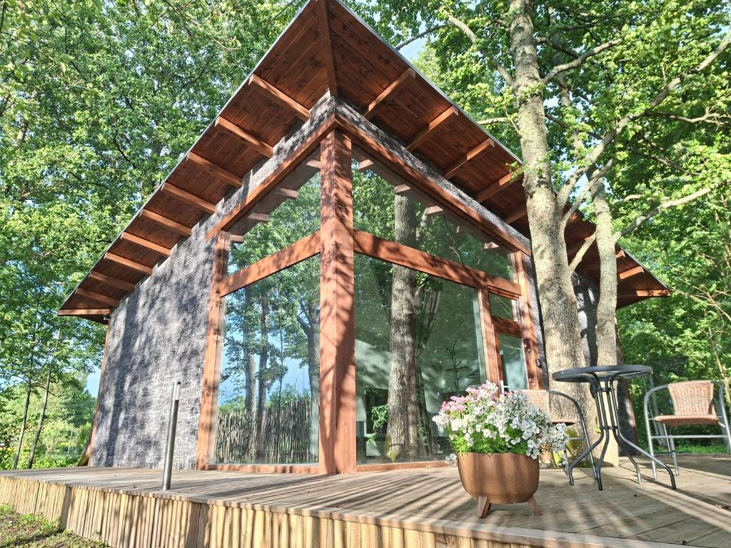 a wooden gazebo with a bench and flowers at DEIVID house for rent in Skulte