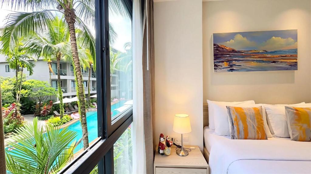 a bedroom with a bed and a view of a pool at Stylish Diamond Condo Bangtao with Pool View in Bang Tao Beach