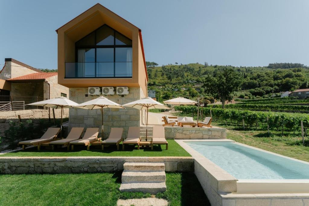 a villa with a swimming pool and lounge chairs at Serpa Pinto Village - Private Pool - by FERO in Cinfães